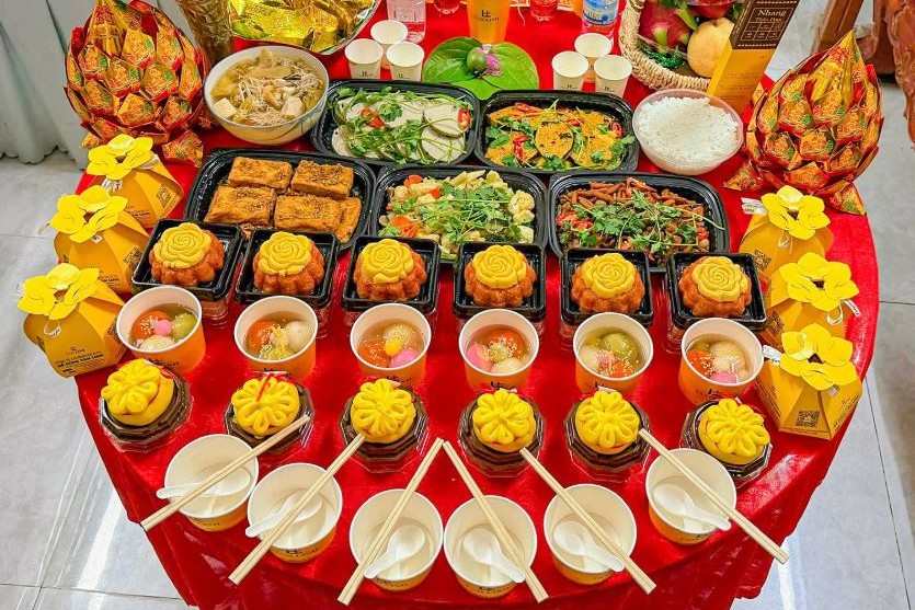 Mâm cúng rằm mùng 1 với hoa cúc vàng, trái cây, xôi, chè bày trên bàn tròn phủ khăn đỏ