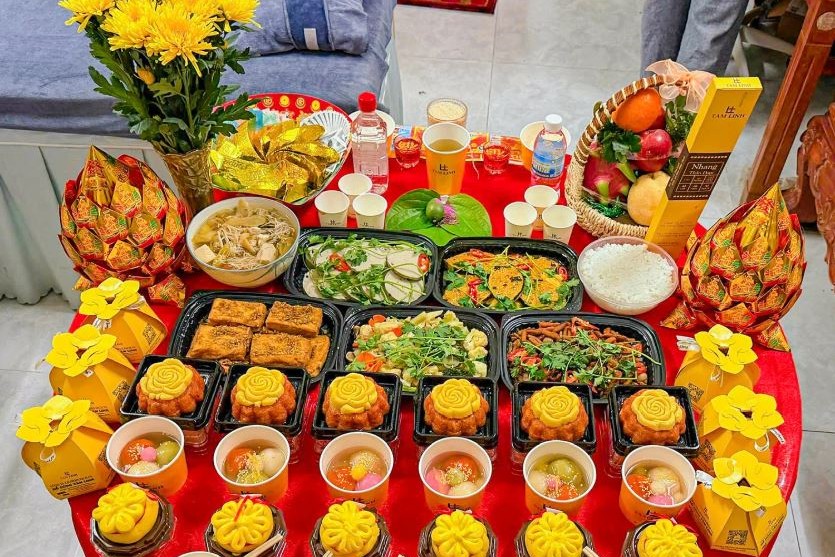Mâm cúng rằm mùng 1 với hoa cúc vàng, trái cây, xôi, chè và mâm cơm chay trên bàn tròn phủ khăn đỏ
