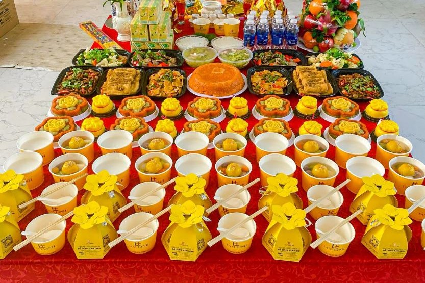 Mâm lễ chay với trái cây, hoa, xôi, chè và các món chay bày trên bàn phủ khăn đỏ