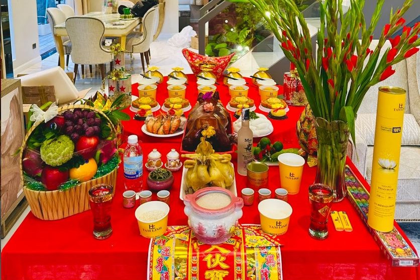 Mâm cúng tổ nghề với gà luộc, heo quay, giỏ trái cây và hoa lay ơn bày trên bàn phủ khăn đỏ