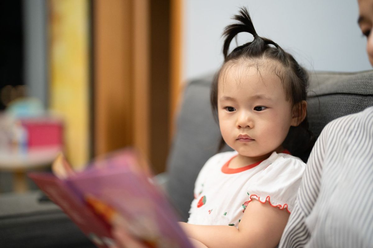 Bé đọc sách cùng người trông trẻ theo giờ