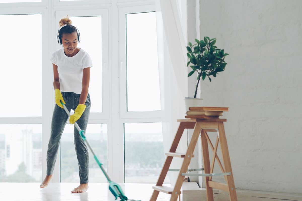 Nhân viên giúp việc văn phòng theo giờ lau sàn phòng làm việc sáng bên cửa kính lớn
